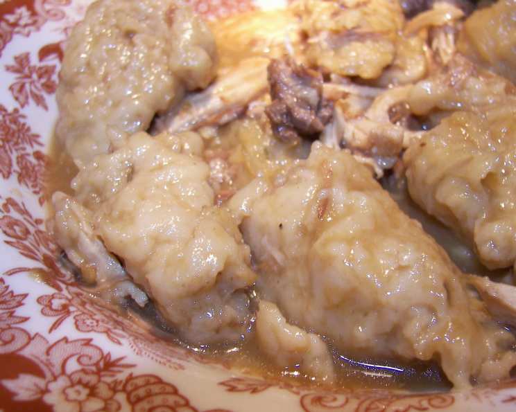 Drop dumplings being added to a simmering pot of chicken soup