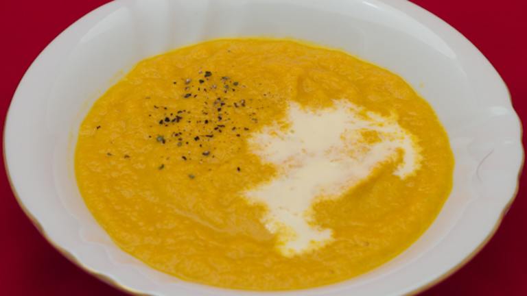Creamy Carrot Ginger Soup in a rustic bowl with fresh herbs