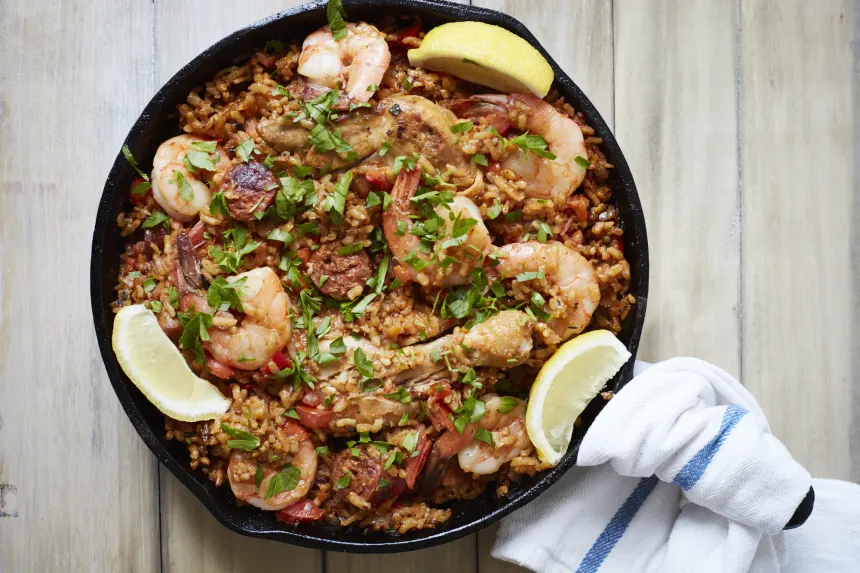 Cooking Traditional Spanish Paella In A Big Iron Cast Pan Stock